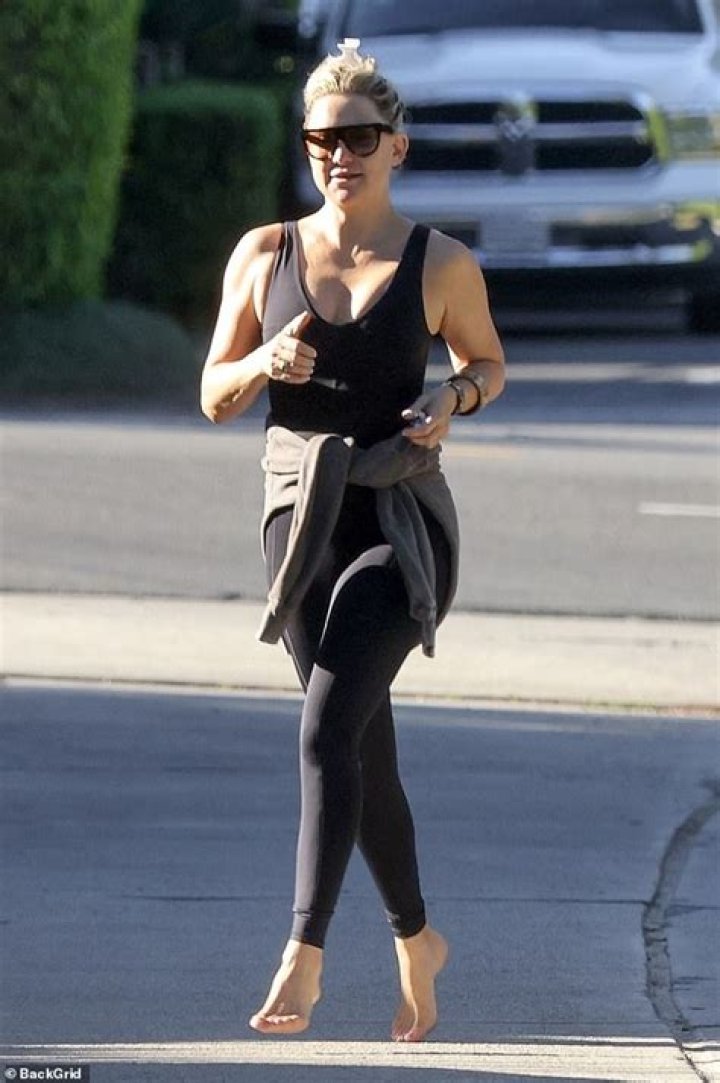 Kate Hudson shows off her sculpted physique in plunging black top and leggings as she walks barefoot